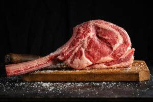 fresh-meat-tomahawk-steak-old-wooden-board-dark-background-closeup_1220-6593.jpg